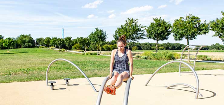 Eine Frau trainiert auf dem Outdoor-Fitness-Parcours