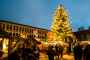 Beleuchteter Weihnachtsbaum und Marktbuden auf dem Neu-Ulmer Rathausplatz