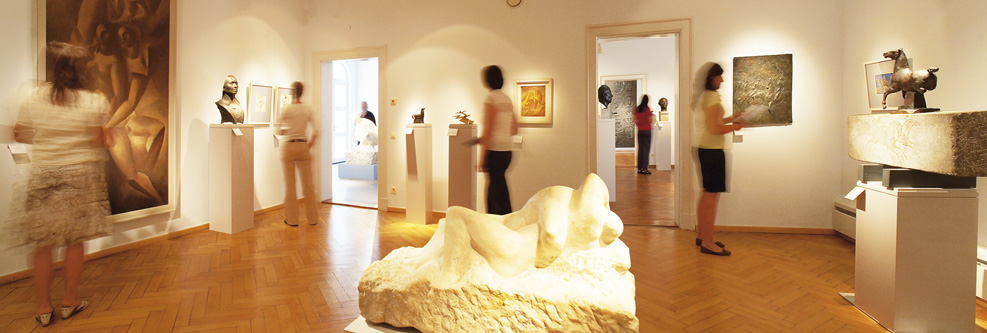 Ausstellungsraum mit Kunstobjekten und Besuchern