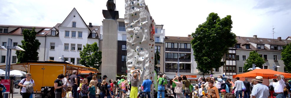 Mobile Kletterwand auf dem Neu-Ulmer Rathausplatz mit Passanten