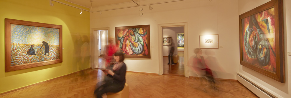Ausstellungsraum mit Gemälden und Besuchern